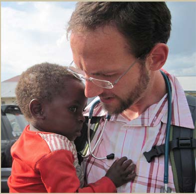 Filmmaker and doctor Chris Carpenter holds a young child in the Congo