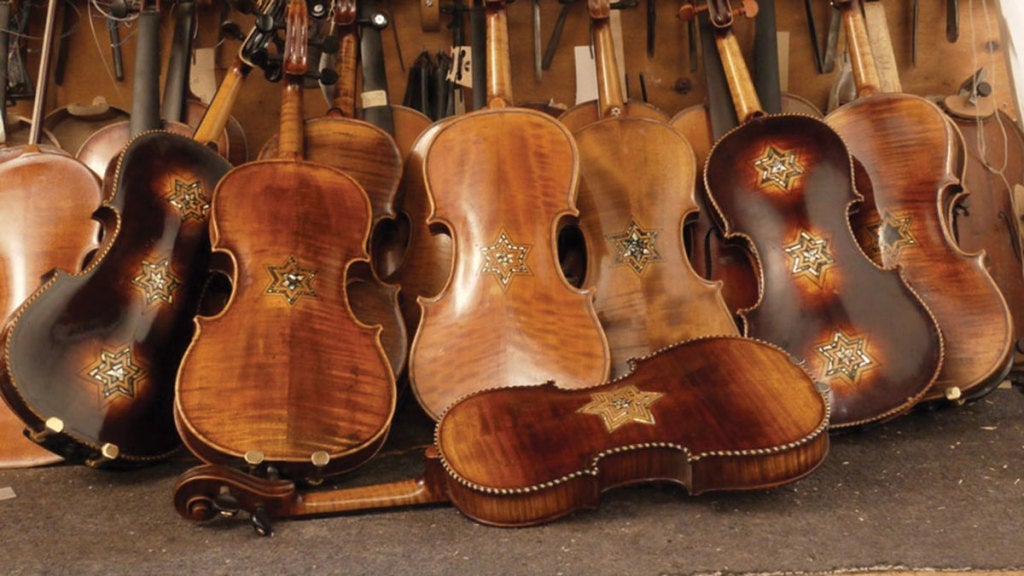 a row of violins as restored for Violins of Hope