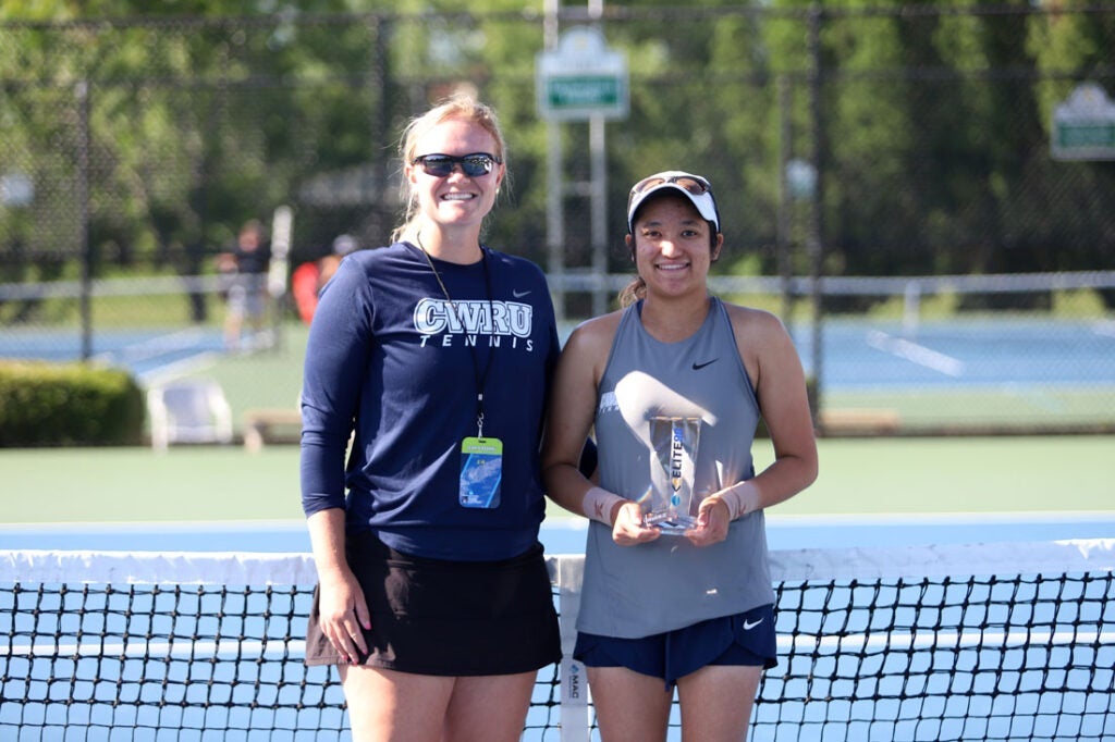 Hannah Kassaie and her coach pose with her Elite 90 trophy