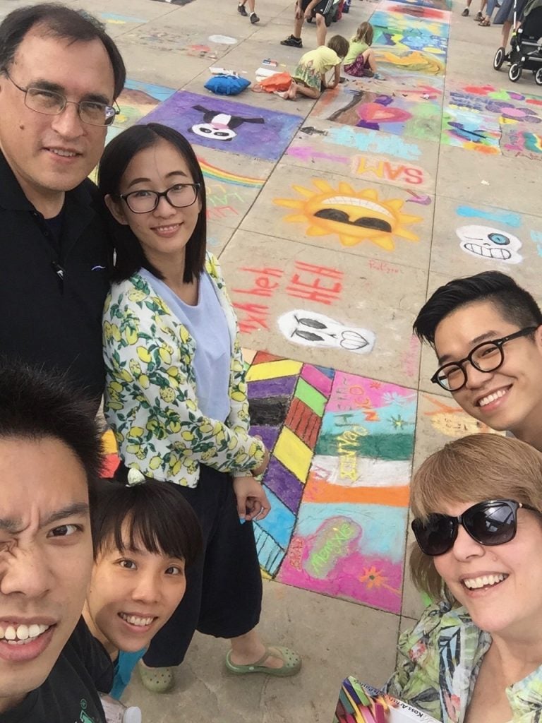 International students and host family selfie at chalk drawing contest