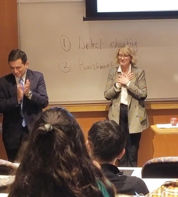 Photo taken from behind students in class showing Jenny Hawkins' reaction when surprised with the Wittke and Jackson Awards