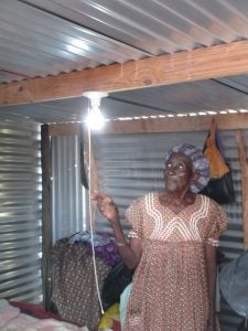 A Namibian women turns on a light in her home after solar panels were installed