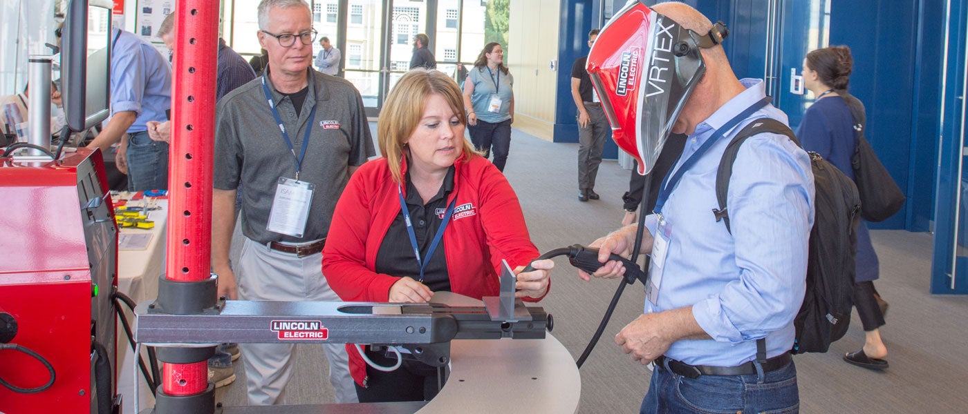 Photo of conference attendee using virtual reality welder.