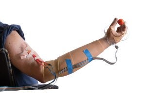 prosthetic arm holding a cherry tomato