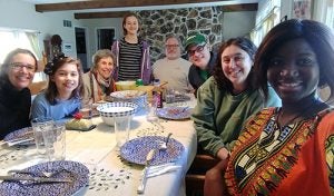 Lisa Kollins and Kayele Silue with Kollins' family sitting around a table