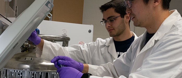 two researchers unload a centrifuge in the lab at Case Western Reserve University