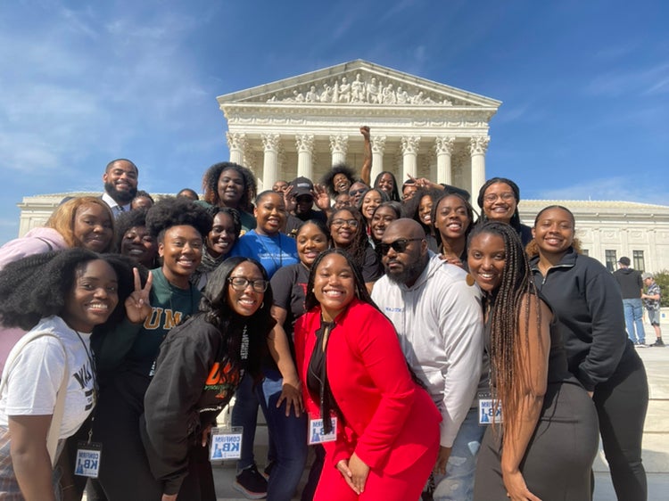 Photo of a group of Black law students posed in front of the U.S. Supreme Court building