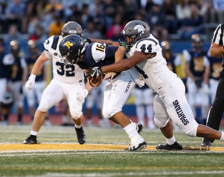 Photo of CWRU alum Cameron Brown (CWR ’20) tackling a player during a NCAA football game. Photography by Chris Cecere.