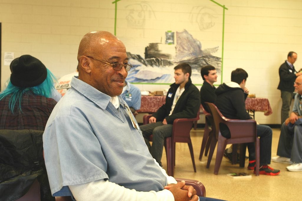 Inmate in the foreground with CWRU students talking to others in the background