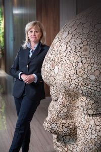Case Western Reserve University alumna Ann McKee next to a statue of a head