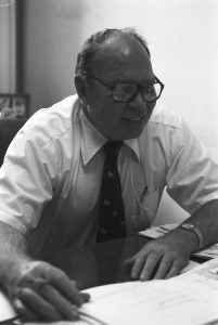 Arthur P. Leary sits at a desk