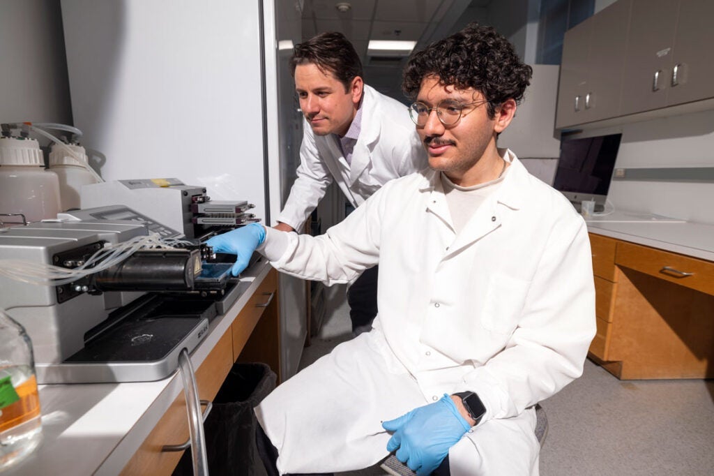 Photo of Ben Clayton working alongside a researcher in his lab