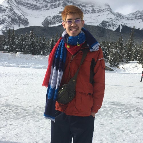 Photo of Benjamin Cheung posing for a photo in a snowy environment with mountains in the background