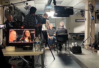 photo showing the 60 Minutes crew taking video of Brandon Prestwood speaking to Scott Pelley