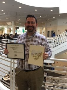Photo of Brian Gray holding certificate
