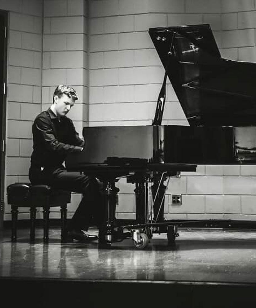 Photo of Caleb Owens playing the piano
