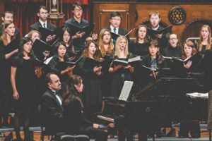 Case Concert Choir performing on stage with two pianists