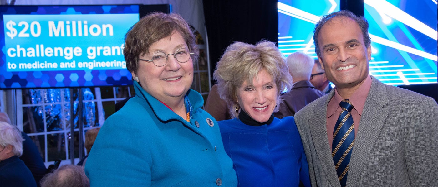 CWRU Medicine Dean Pamela B. Davis, President Barbara R. Snyder and Engineering Dean Ragu Balakrishnan pose in front of a sign that reads "$20 million challenge grant to medicine and engineering"