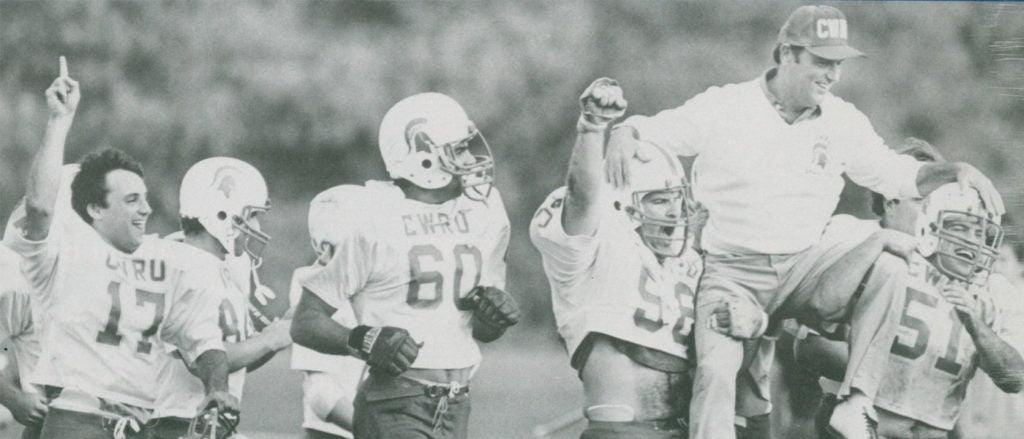 Black and white photo of CWRU football players carrying coach Jim Chapman off the field in celebration