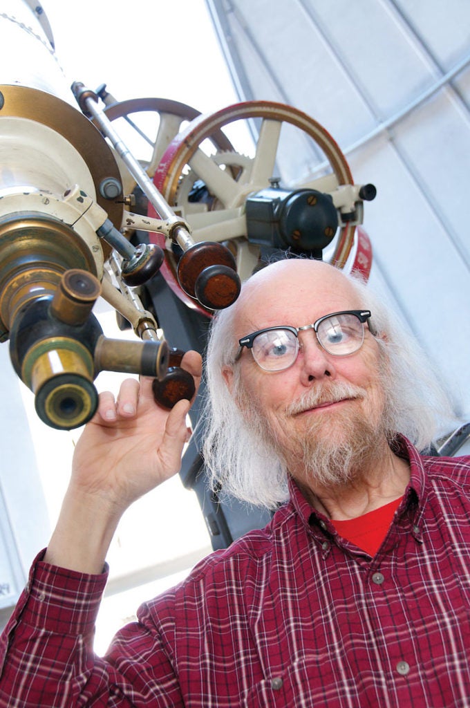 Photo of Charley Knox posing with a telescope
