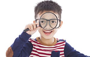 young child playing with a magnifying glass