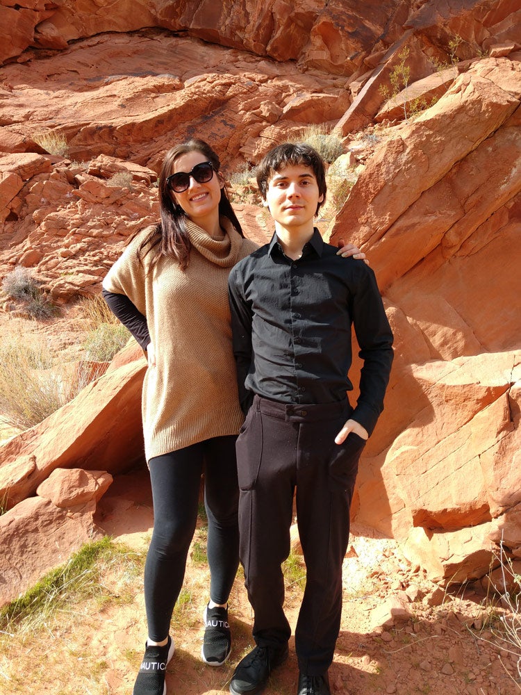 Photo of Christopher Lysyj and his sister posing for a photo in front of a rock formation