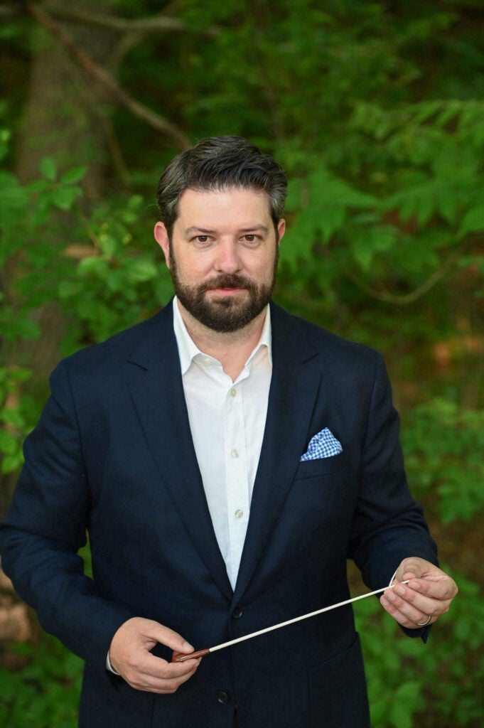 Photo of Christopher Clark holding a director's baton