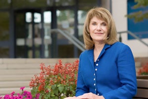 claudia coulton sits in front of the Mandel School