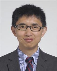 Portrait of Feixiong Cheng wearing blue dress shirt, dark suit jacket and tie.