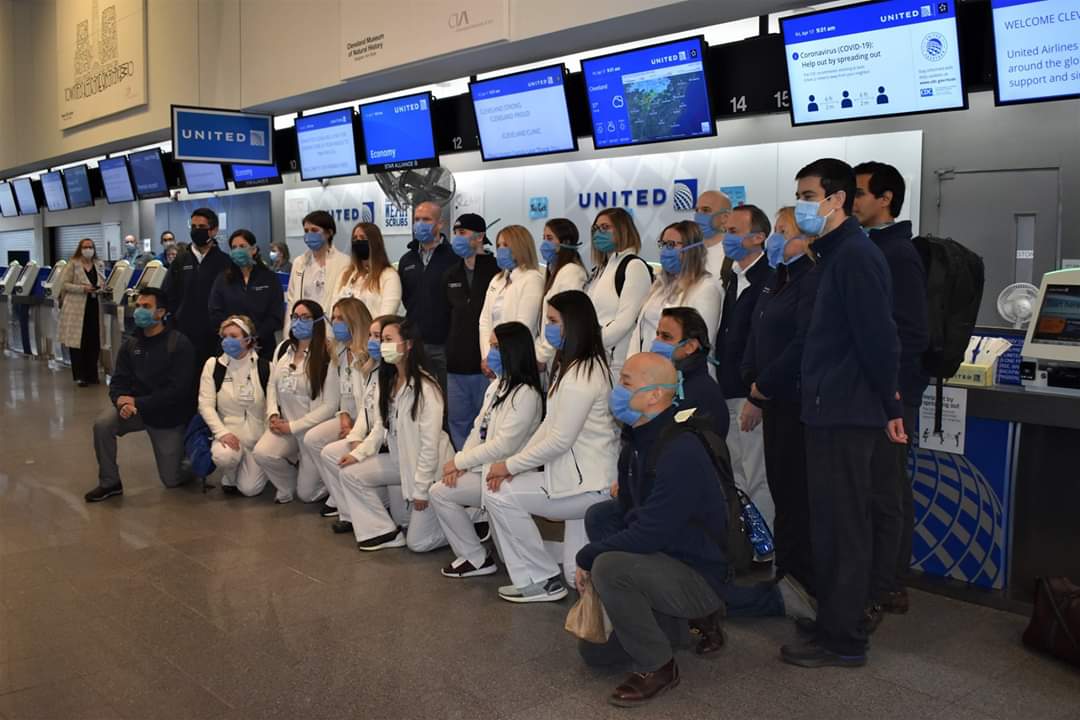 A group of Cleveland Clinic staff pose at the airport wearing masks made by CWRU volunteers