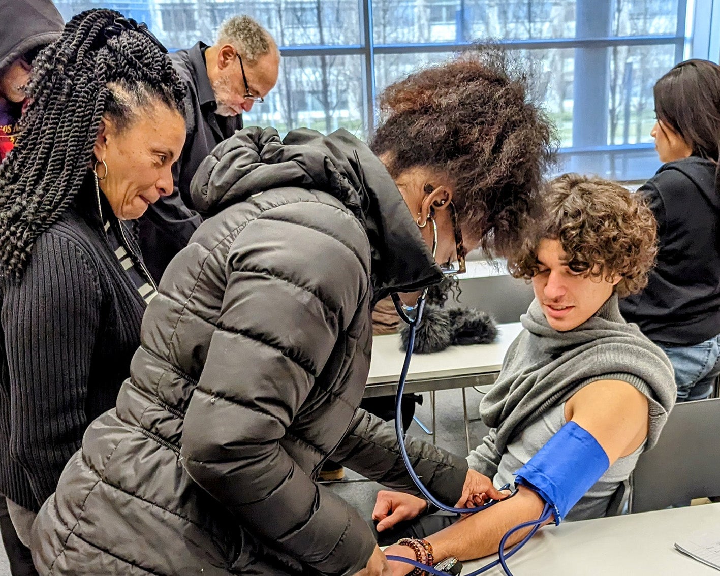 high school student taking blood pressure of another high school student