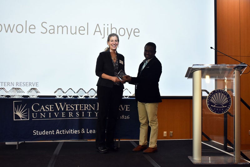 Ayowole Samuel Ajiboye receives an award on stage