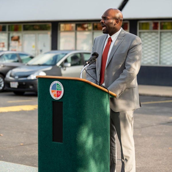 Leon Harris speaking at a City of Cleveland podium outside