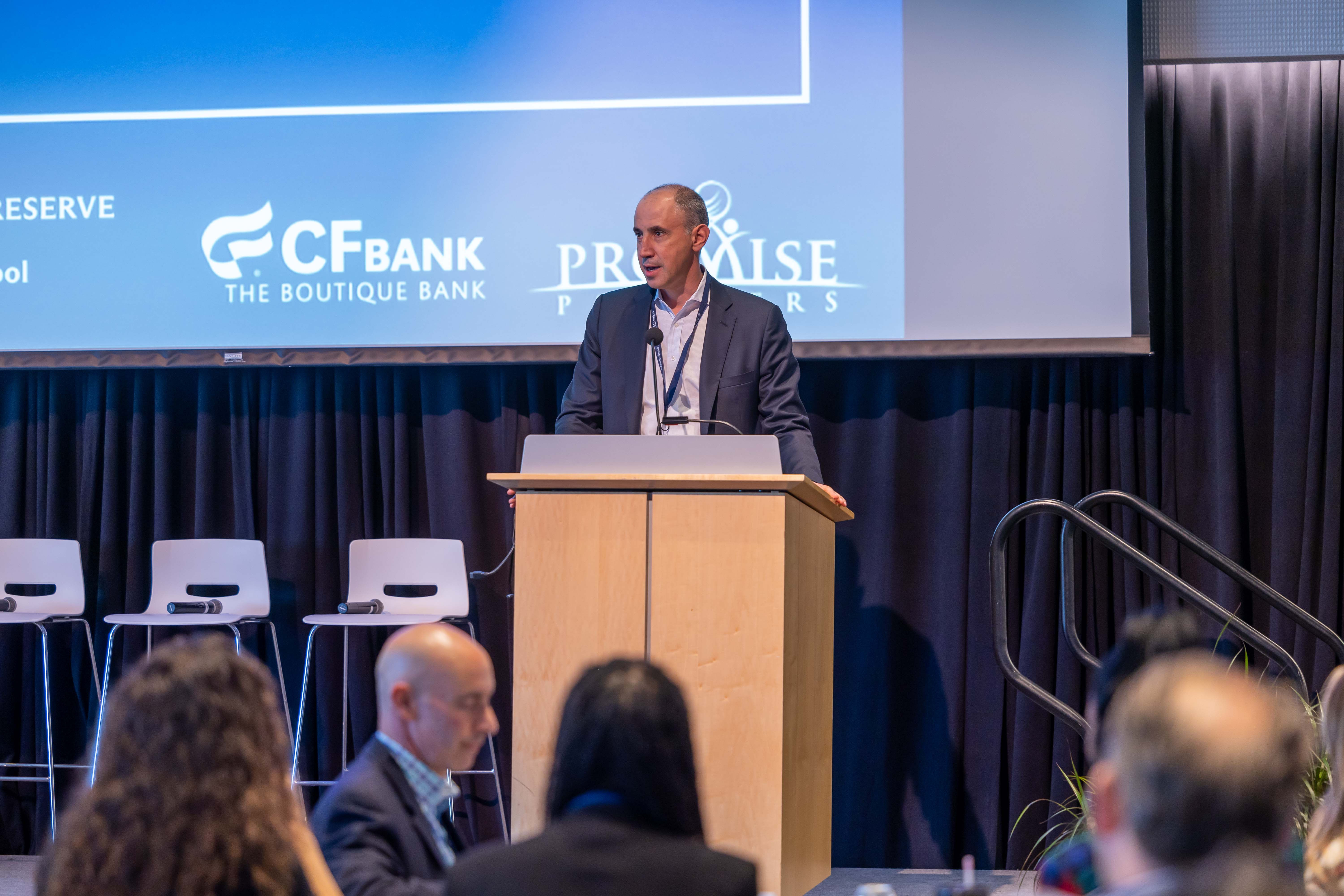 Dean Andrew Medvedev of the Weatherhead School of Management speaks from a podium on a stage