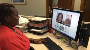 a woman sitting at her computer looking at the new daily website