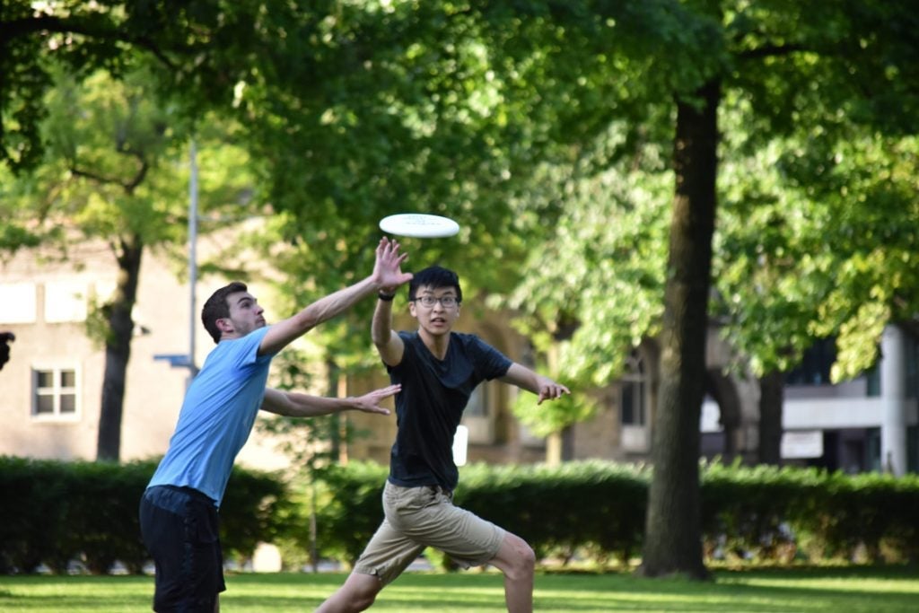 Photo of Daniel Shao and a friend both vying to catch a frisbee