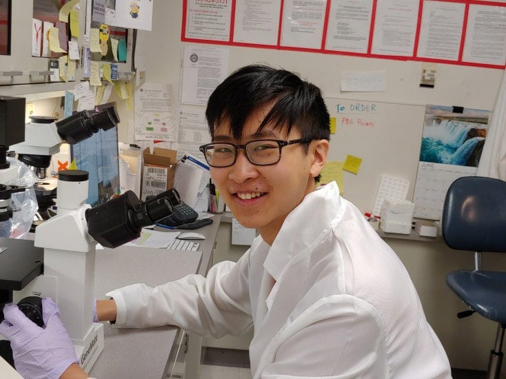 Photo of Daniel Shao smiling while posed at the bench conducting research
