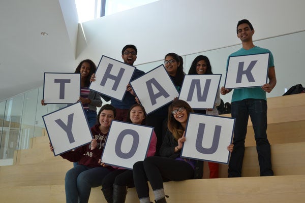 CWRU students hold signs spelling "thank you" on steps at the Tink