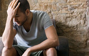 photo of young man holding hand on head
