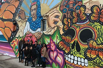Students pose in front of mural in Detroit as part of Alternative Spring Break program