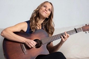 Photo of Diana Chittester playing the guitar
