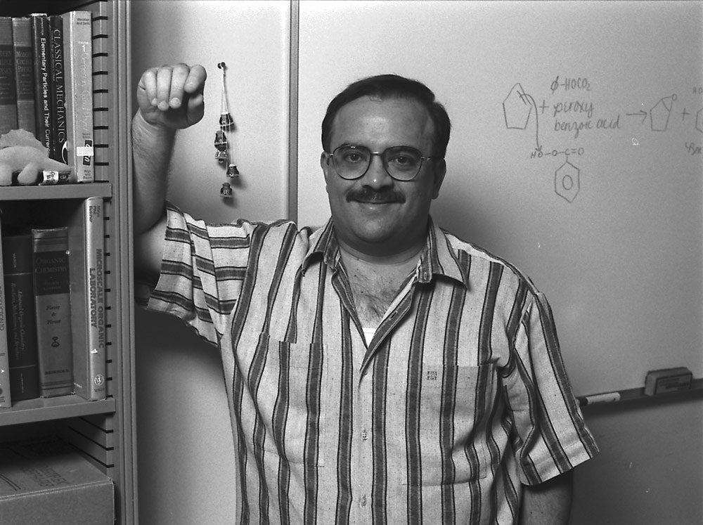 Photo of Doc Oc posing next to a bookcase