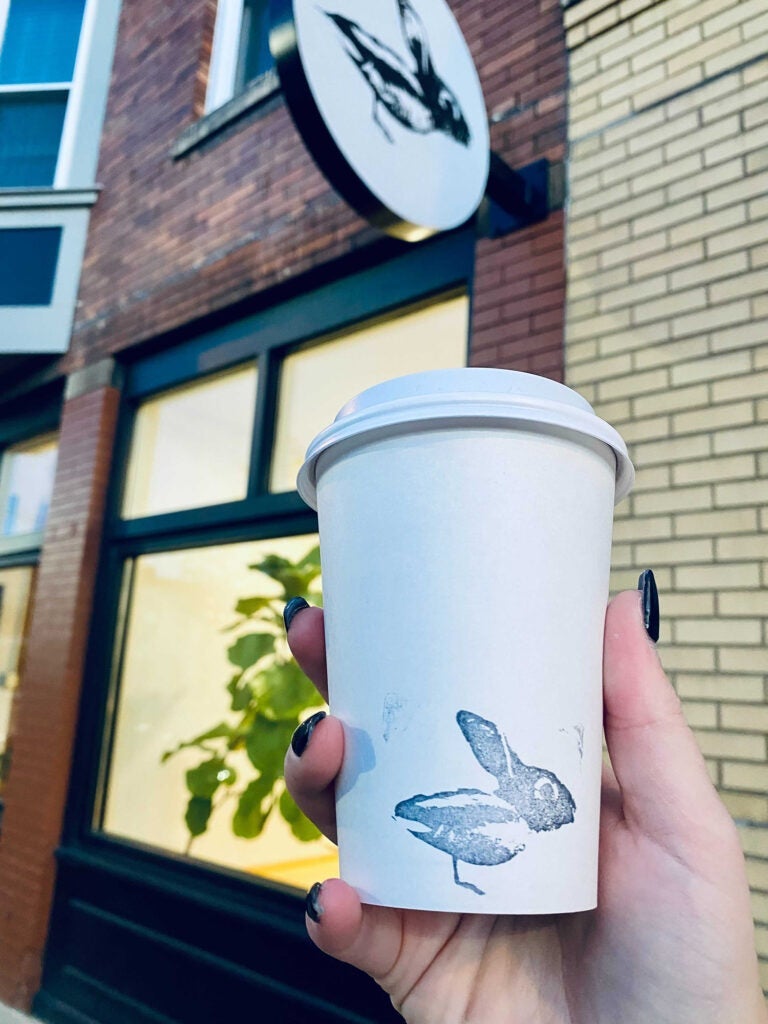 A woman holding a cup of coffee.
