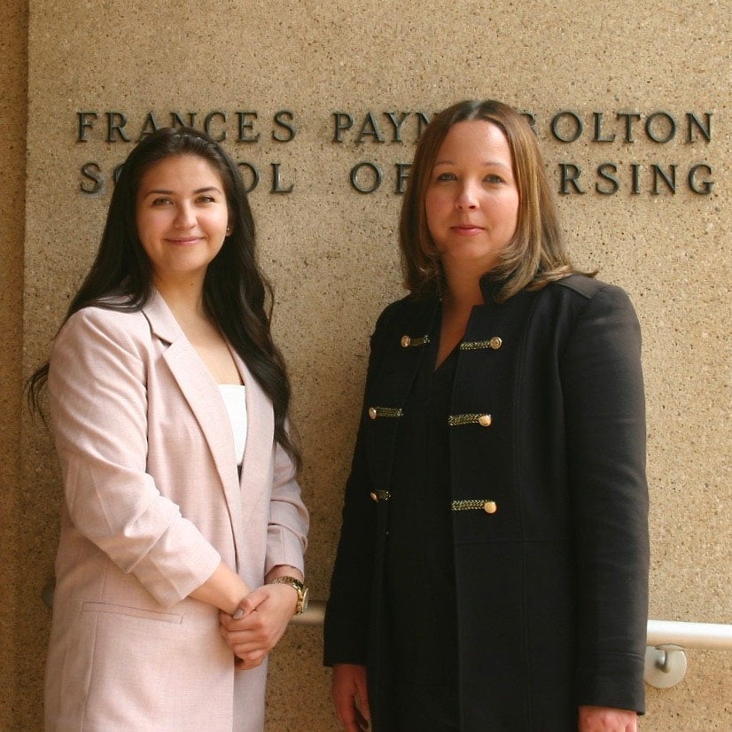 Photo of Estefania Hernandez and Stephanie Griggs in front of signage for the Frances Payne Bolton School of Nursing