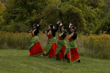 Photo of four members of a student group dancing at the Farm Harvest Festival