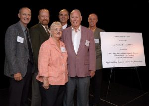 The Leary family stands next to a dedication board at a university event