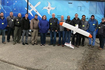 A group photo of the participants in the flight test and the small airplane