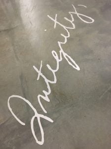 Guess where photo of the word "integrity" inscribed in concrete floor