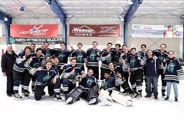 Photo of the ice hockey team posing for a photo on the ice