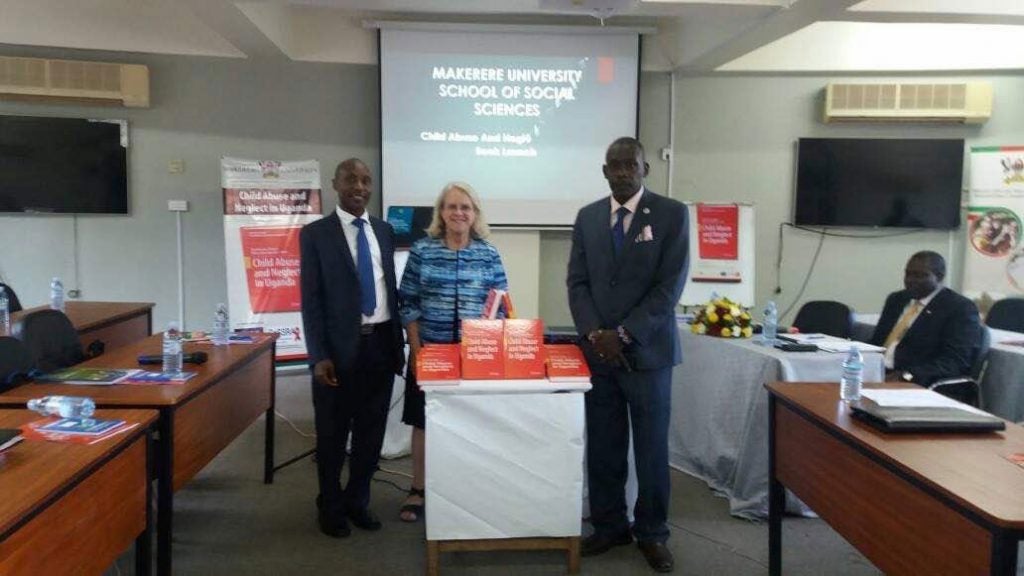 Photo of David Kaawa-Mafigiri, Jill Korbin and Eddy Walakira with table with books on it